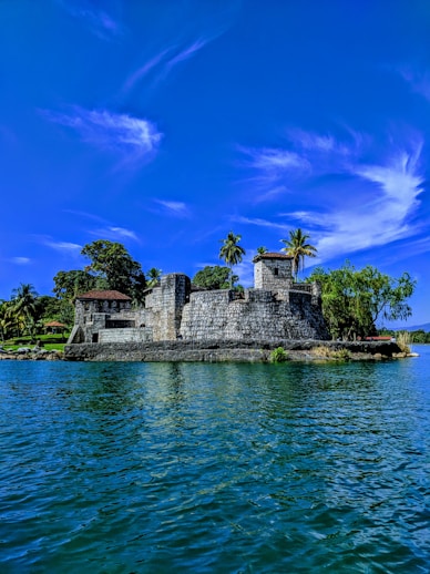 grey concrete building surrounded by trees under clear blue sky