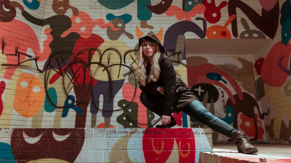 woman in black hoodie sitting near wall art