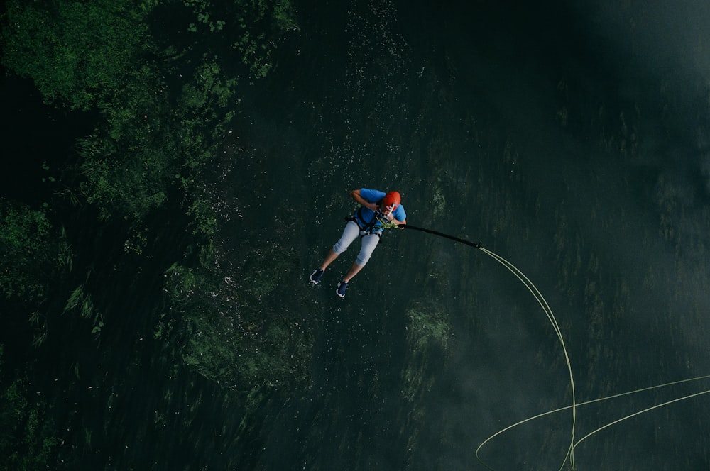 Un homme saute dans un plan d’eau avec une corde de sécurité