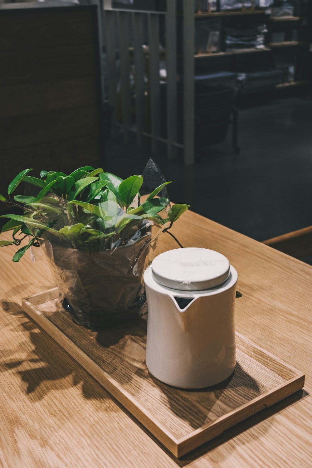 white teapot on top of brown wooden tray on top of brown wooden table