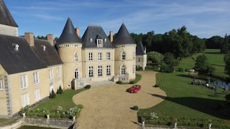 aerial view photography of red vehicle park in front of building