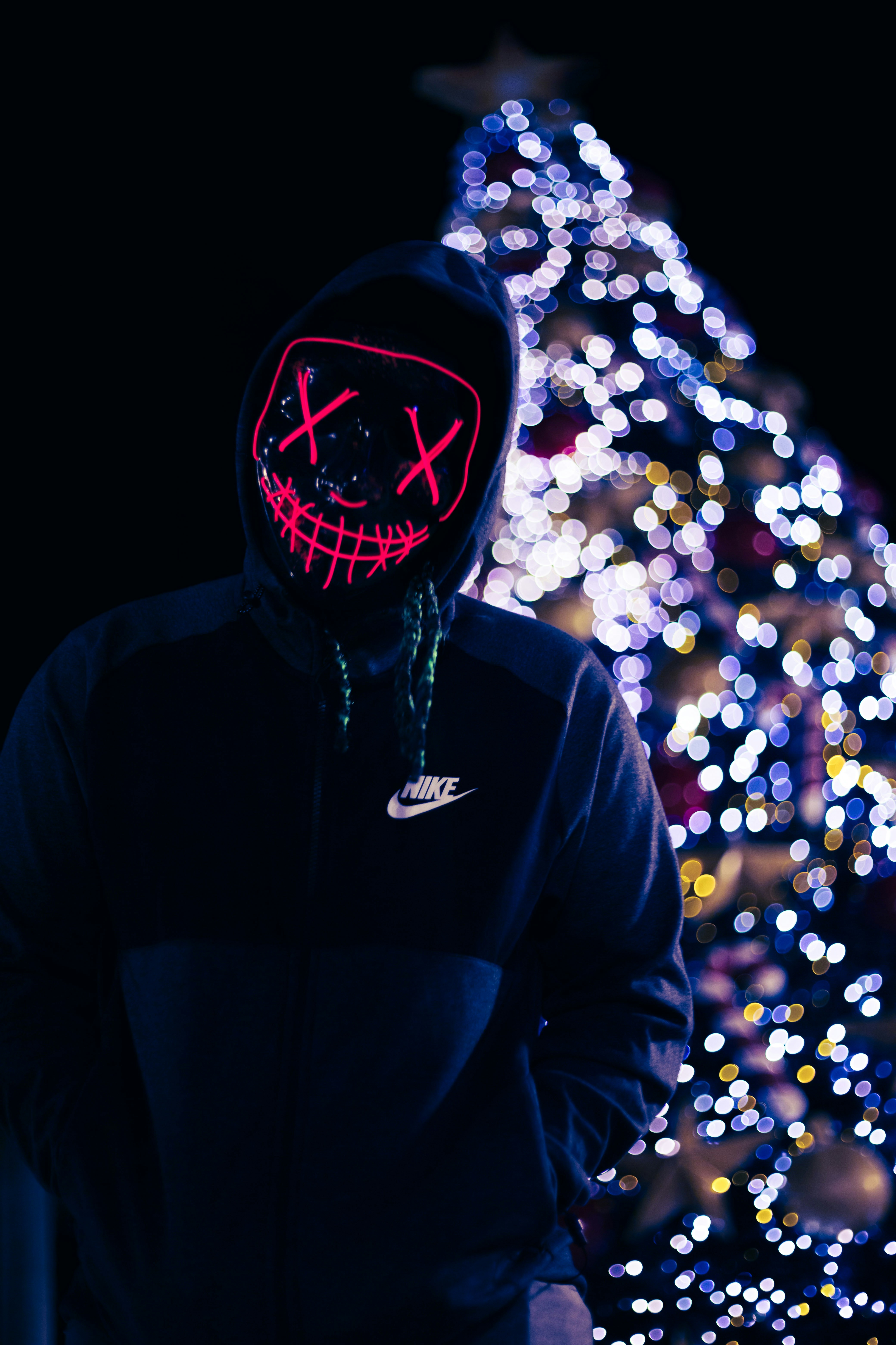 person in blue Nike hoodie near christmas tree