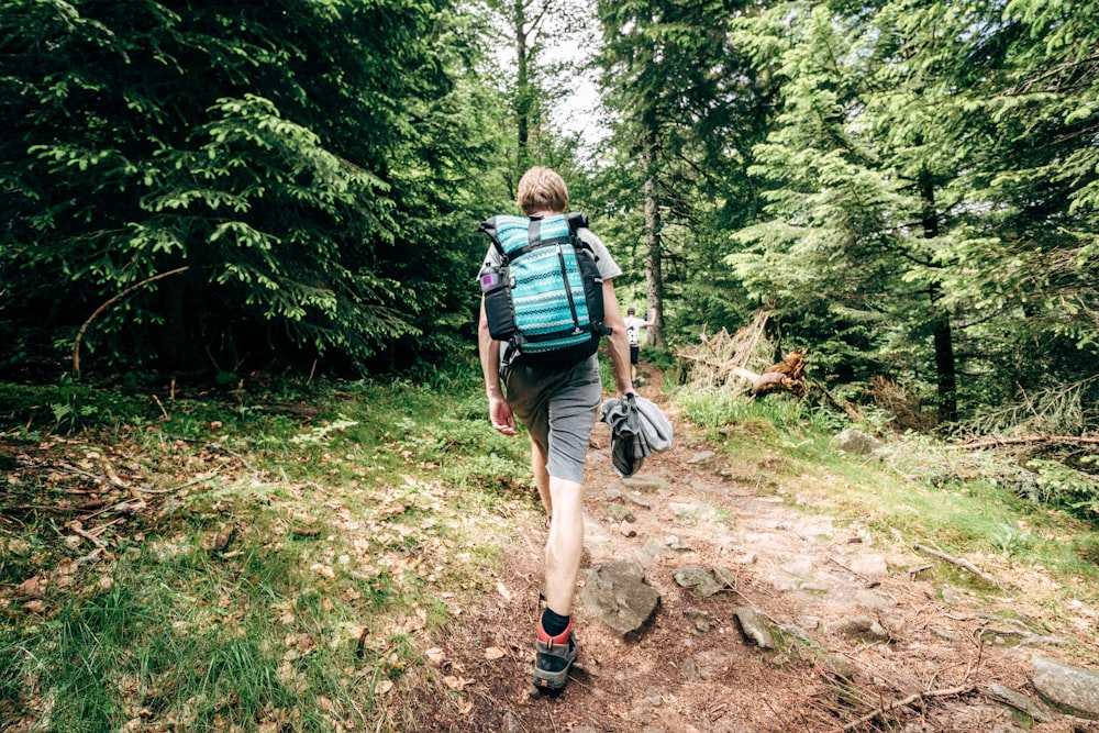 man hiking on forest at daytime