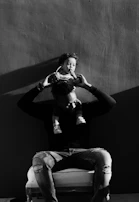 grayscale photography of man lifting a girl