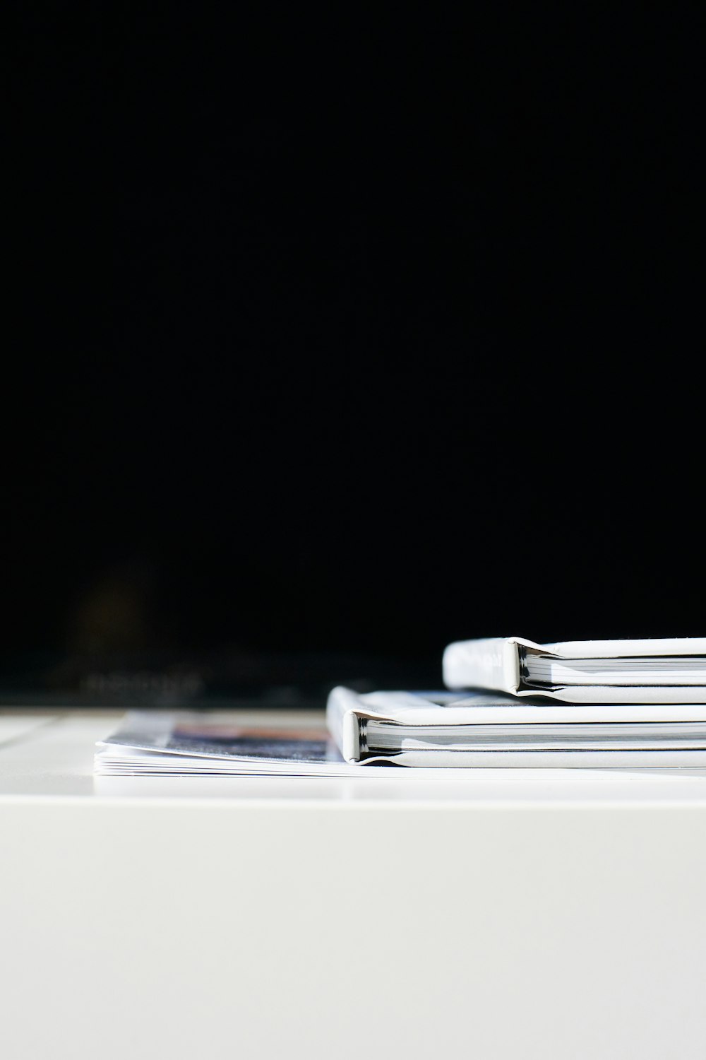 a stack of magazines sitting on top of a white table