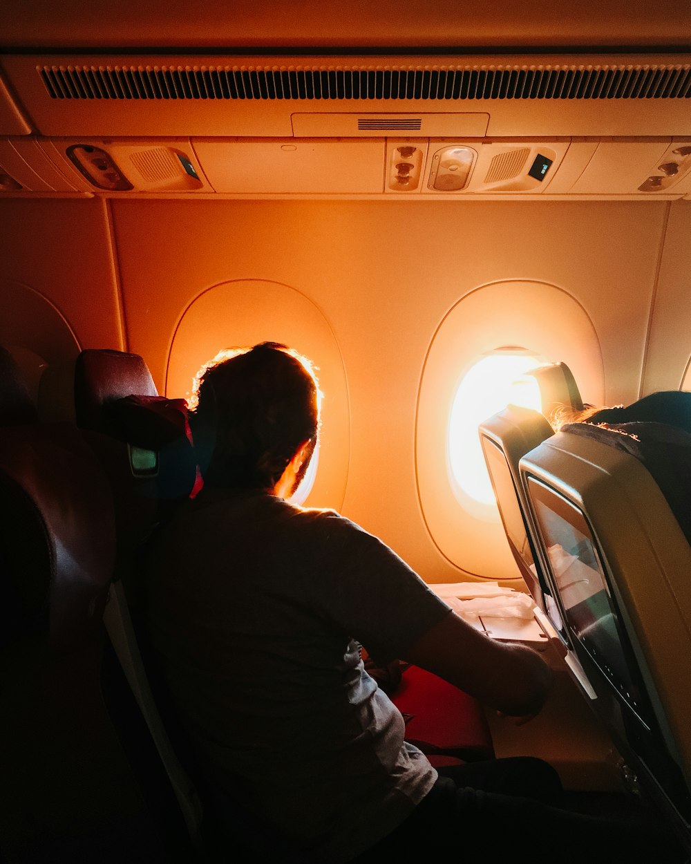 man sitting on airplane beside window
