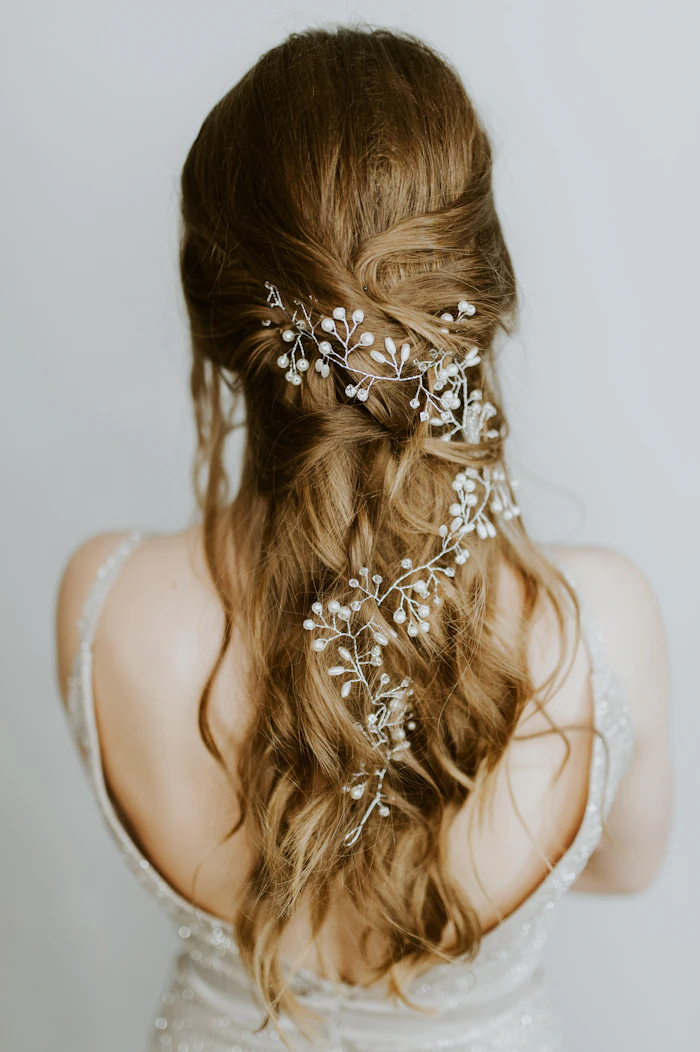 Bridal hairstyle finished with a delicate floral accent