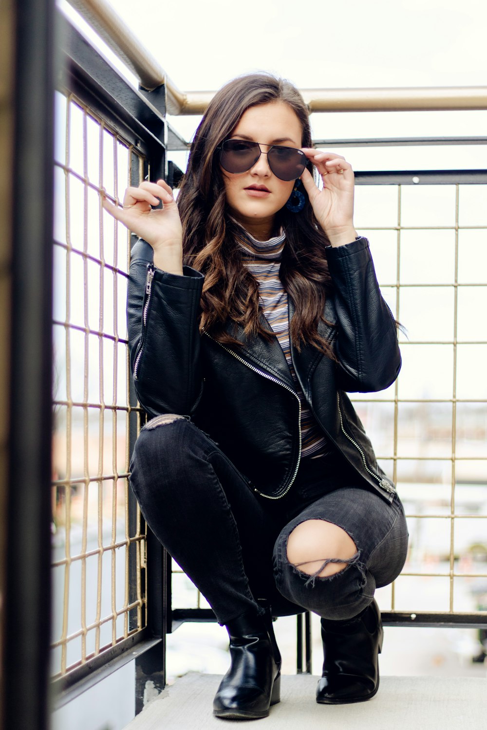 woman wearing sunglasses and blue leather jacket