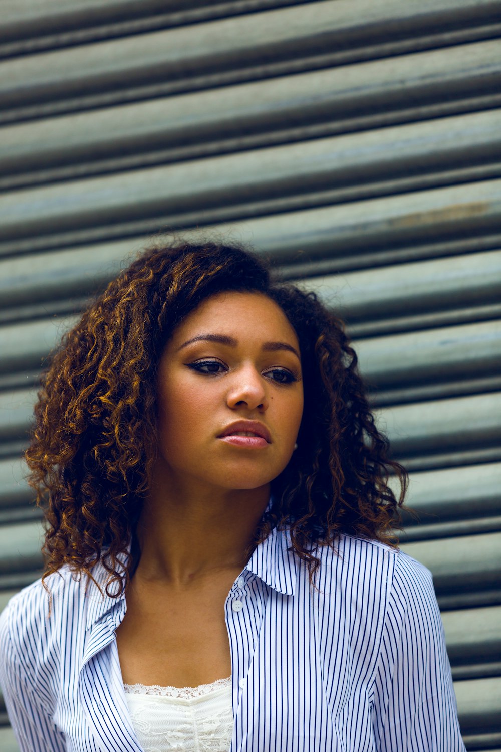 woman standing beside grey wall