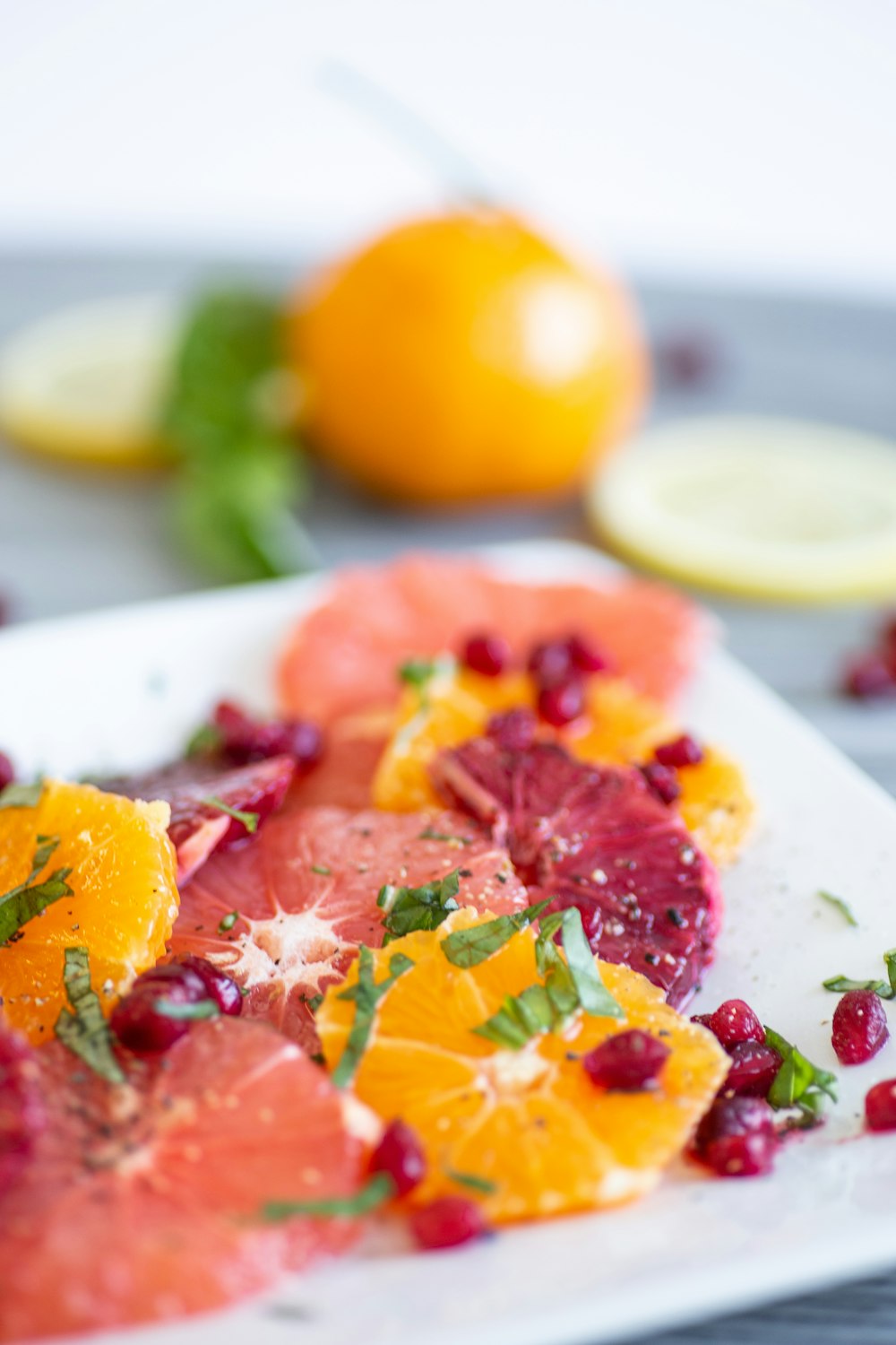 Photo de mise au point peu profonde de fruits tranchés sur un plateau en céramique blanche