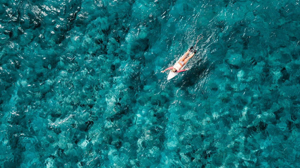 bird's eye view of person surfing on body of water