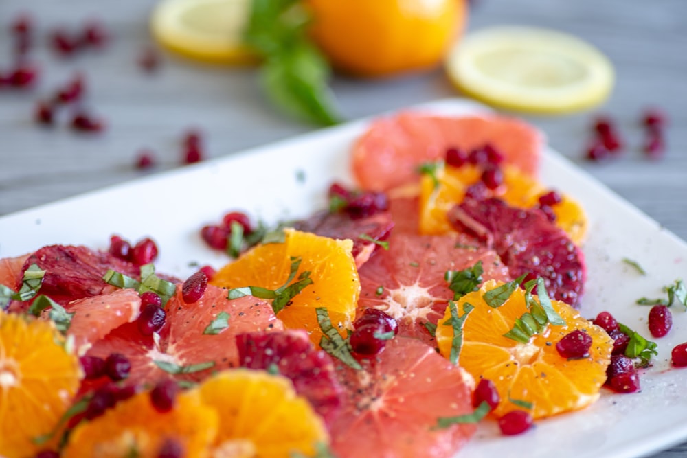 shallow focus photo of sliced fruits on white ceramic tray