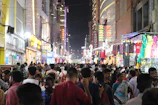 Vibrant night market scene in bustling Bangkok with colorful lights.