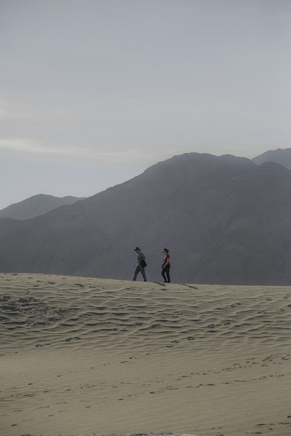 two women walking on dessert during daytime