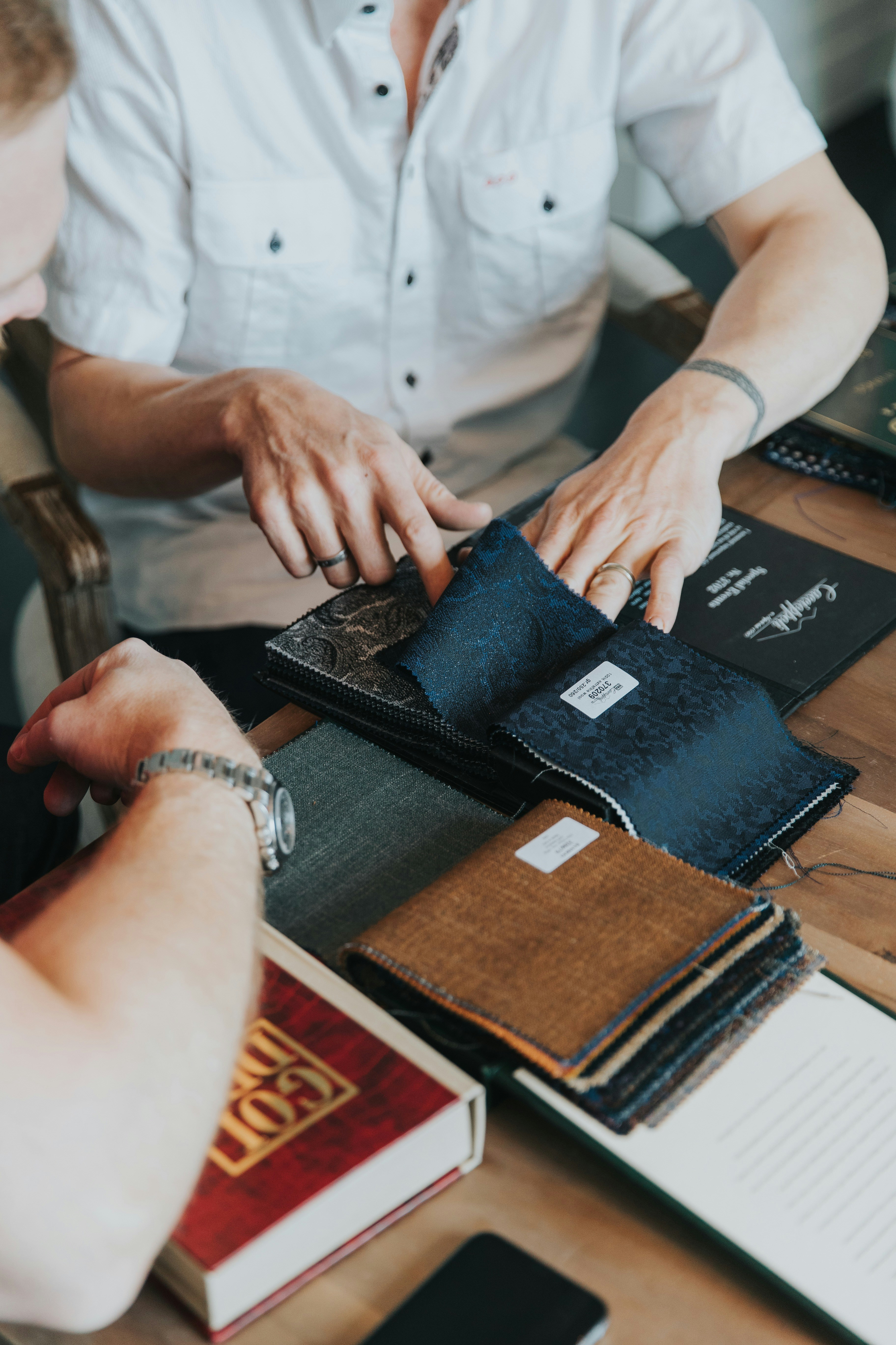 person in white button-up shirt holding black paper