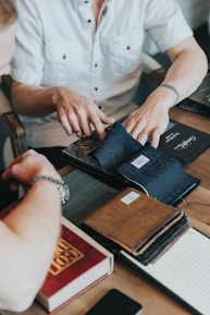 Close-up of a designer guiding a client through fabric and print options in the shop.