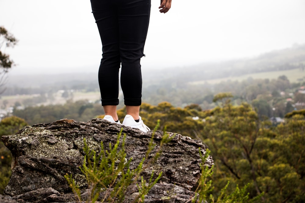 person standing at the edge of cliff during daytime