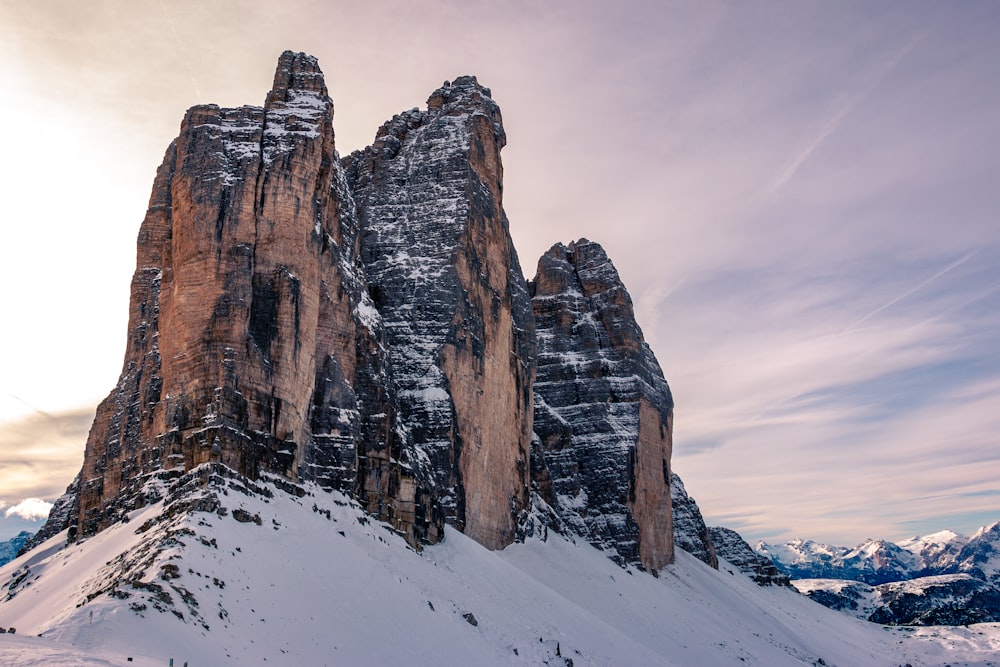 snow covered brown cliff under white sky