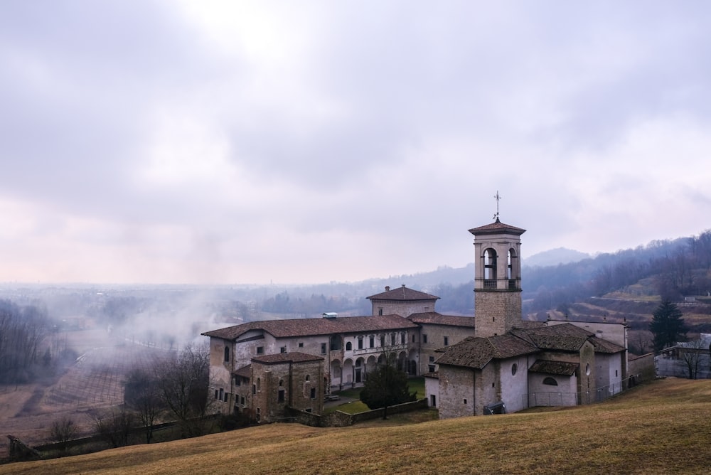 grey stone church on mountain slope under grey cloudy sky