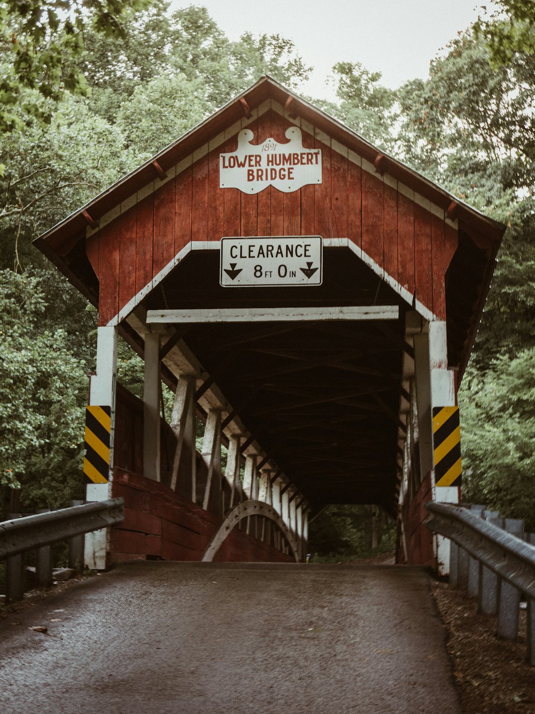 brown and white wooden bridge under white sky beside trees