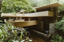 beige and brown brick house between trees