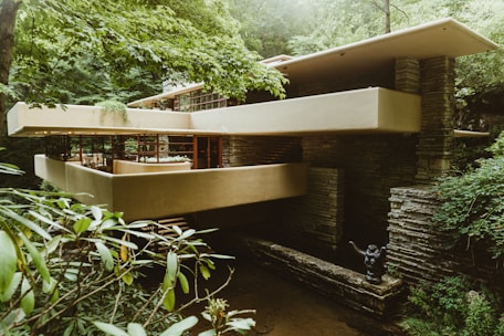 beige and brown brick house between trees