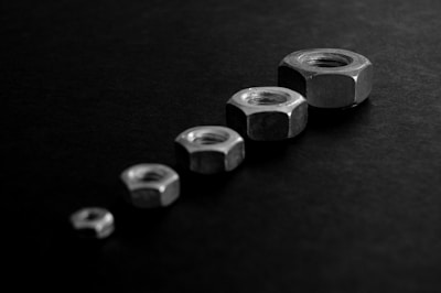 Various sizes of motorcycle nuts displayed on a metal tray with soft lighting