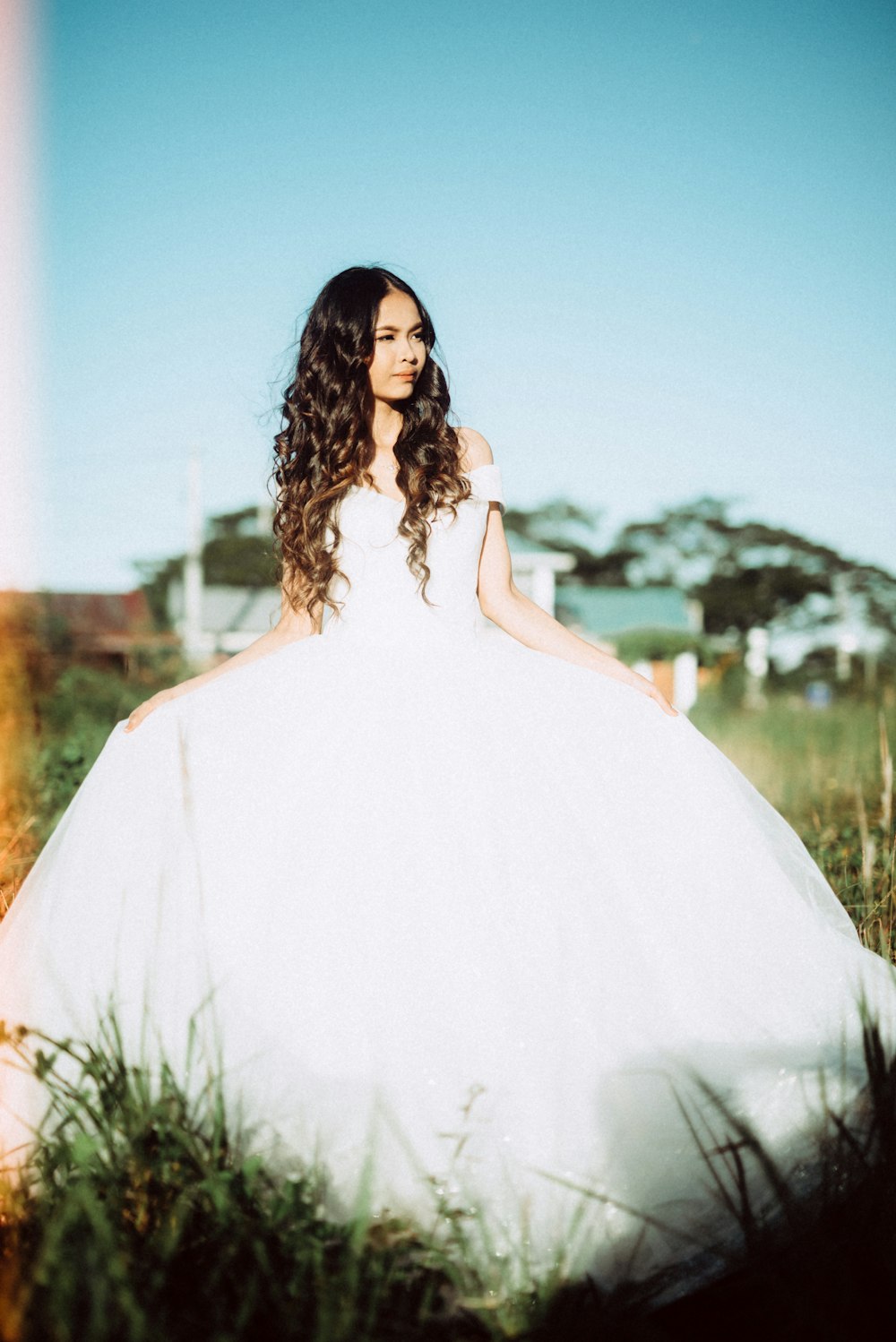 woman in white dress standing on grass field