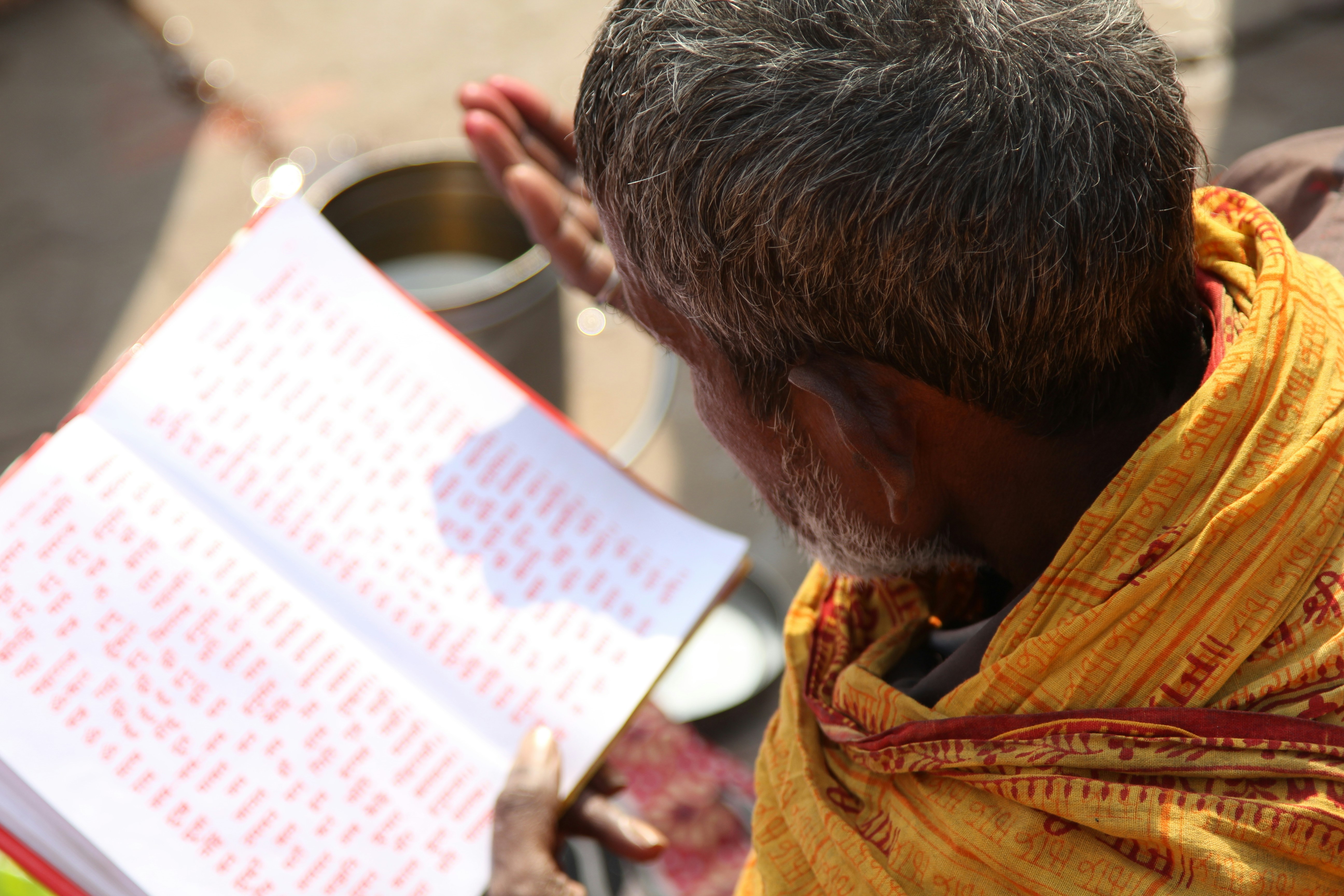 man in yellow robe holding book