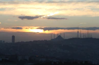 A scenic view of Berlin’s skyline with a mosque minaret in the foreground at sunset.