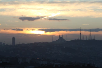 A scenic view of Berlin’s skyline with a mosque minaret in the foreground at sunset.