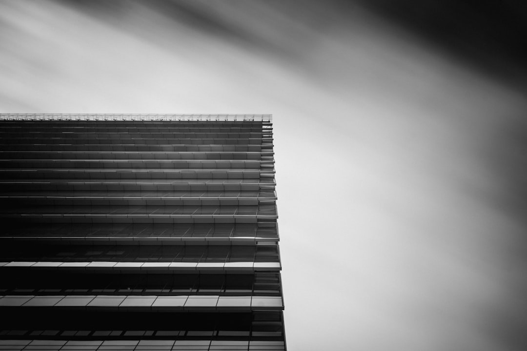 low-angle and grayscale photography of curtain wall building