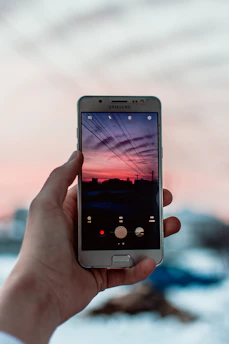 A close-up of a hand holding a phone displaying solar energy savings.