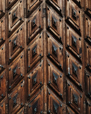 A tribal-inspired pattern carved onto a wooden surface, echoing our logo’s geometry.
