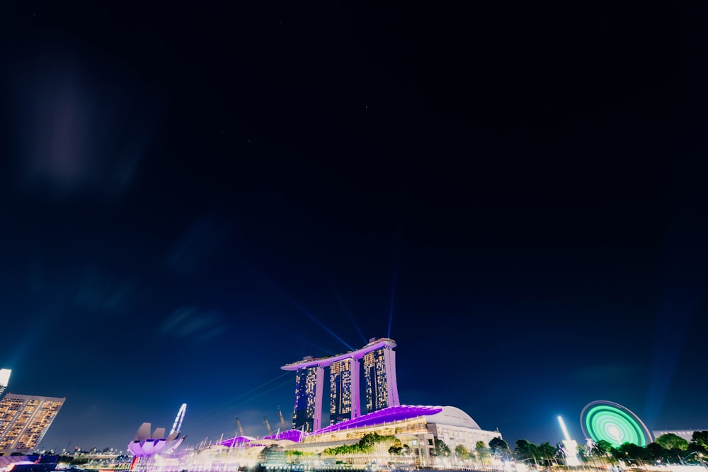 edifício de concreto roxo e preto sob o céu azul durante a noite