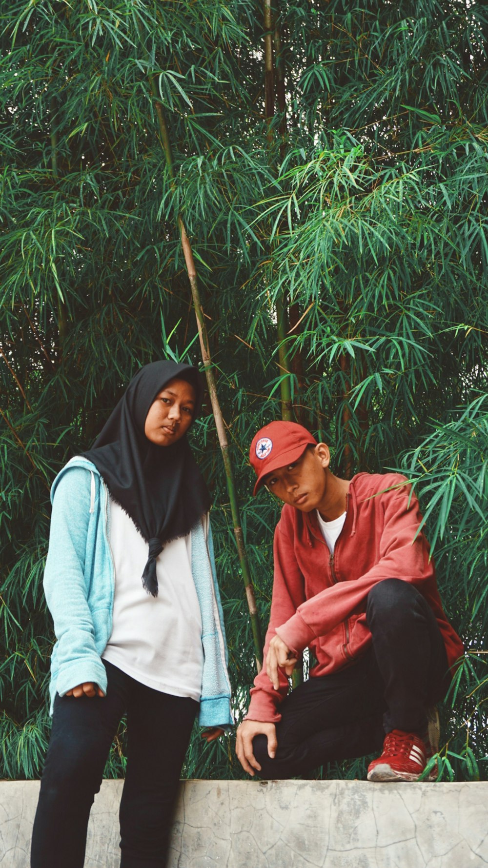 man and woman standing beside bamboo grass