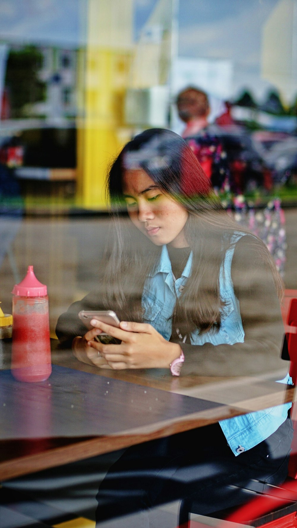 woman sitting on chair using smartphone