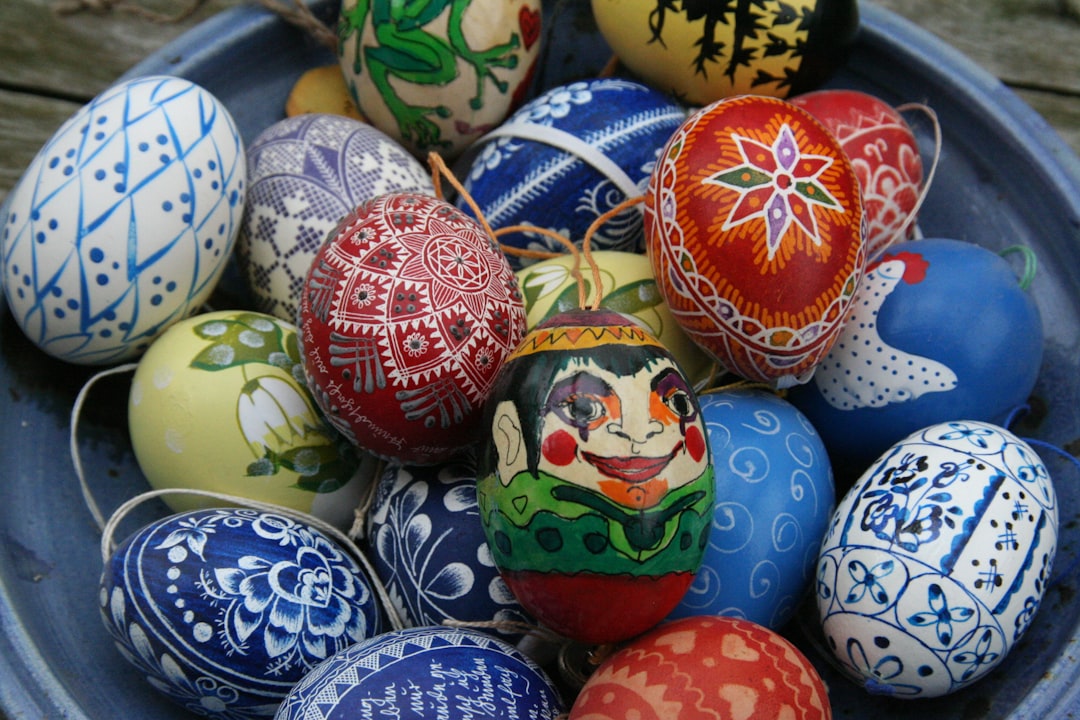 assorted-color Easter eggs on bowl, I painted the little guy in the middle myself with water colour. It’s an old tradition here in Germany to hang pretty decorated eggs up round Easter. There are lots of ways to decorate them, for example with wax, paint, fabric, or by scratching patterns out.