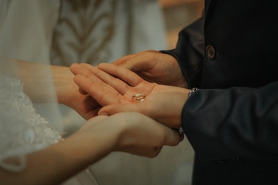 Close-up of hands holding wedding rings during a heartfelt ceremony.