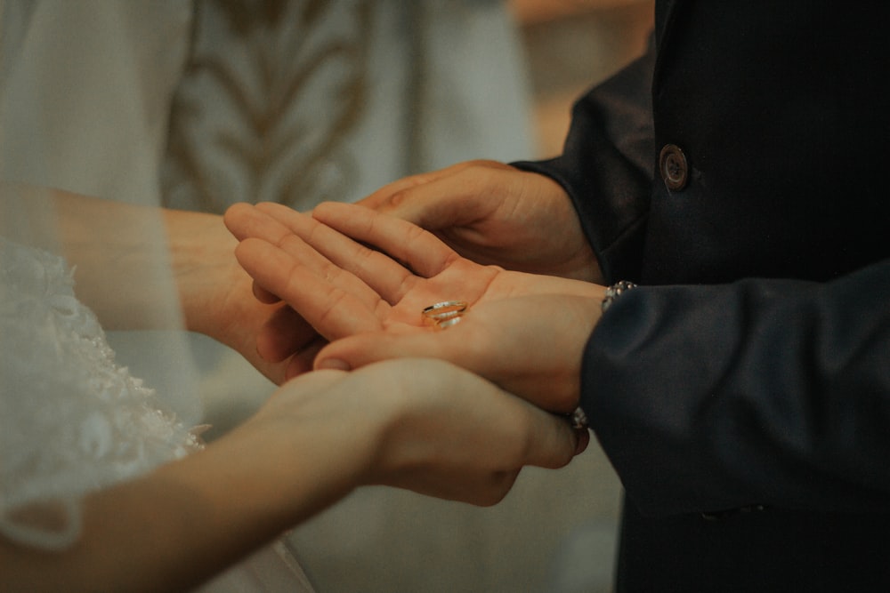 man and woman holding hands with ring on hand