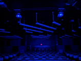 A panoramic view of the modern MBQ Academy classroom bathed in deep navy and emerald lighting.