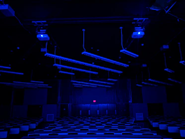 A futuristic classroom setting with students engaged in STEM innovation labs illuminated by soft navy and cyan lighting.