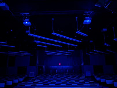 A futuristic classroom with students engaged in robotics and AI projects under neon blue lighting.