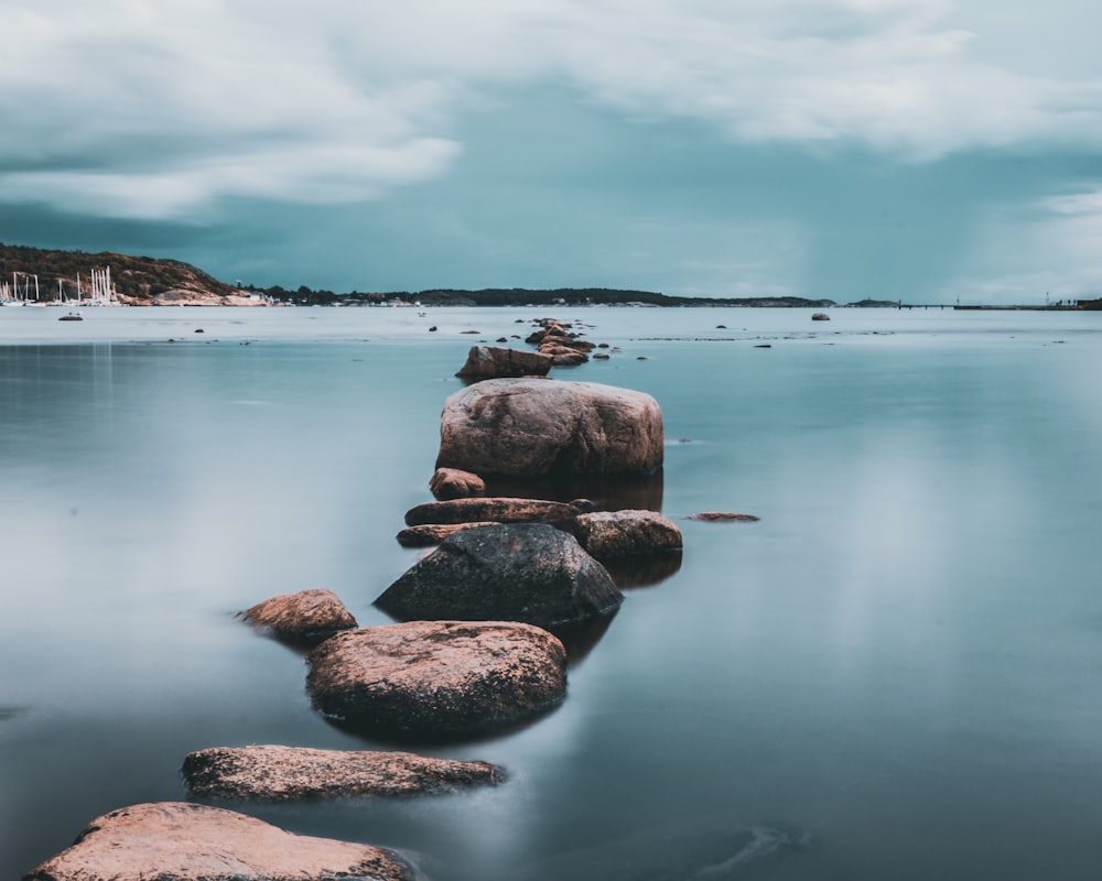 brown rock pathway between calm lake