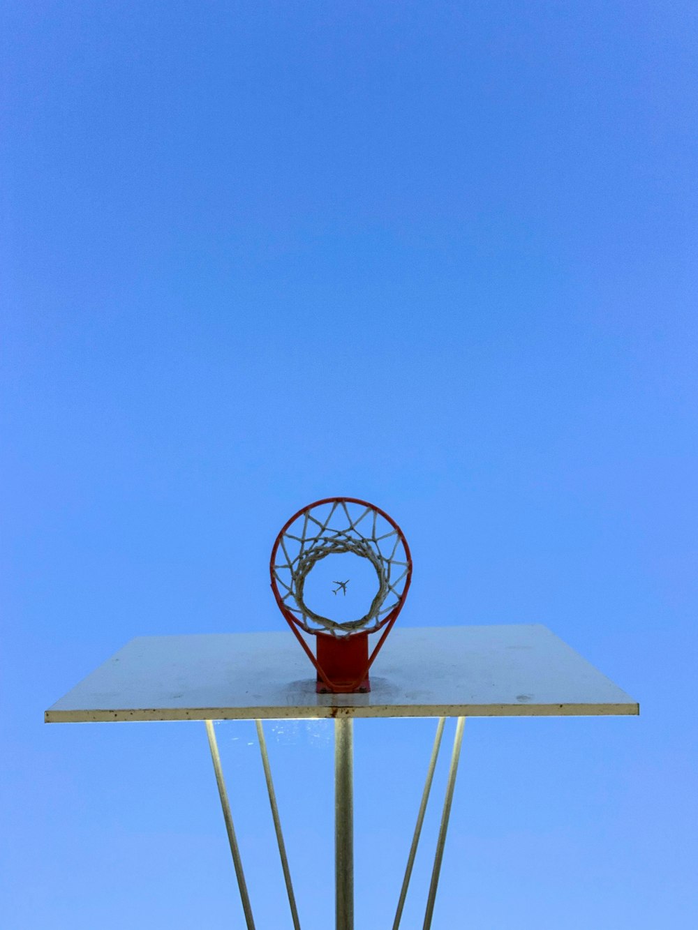青空の下で赤と白のバスケットボールフープ