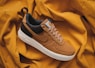 brown Nike sneaker on yellow textile