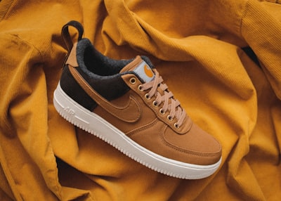 brown nike sneaker on yellow textile clothing zoom background