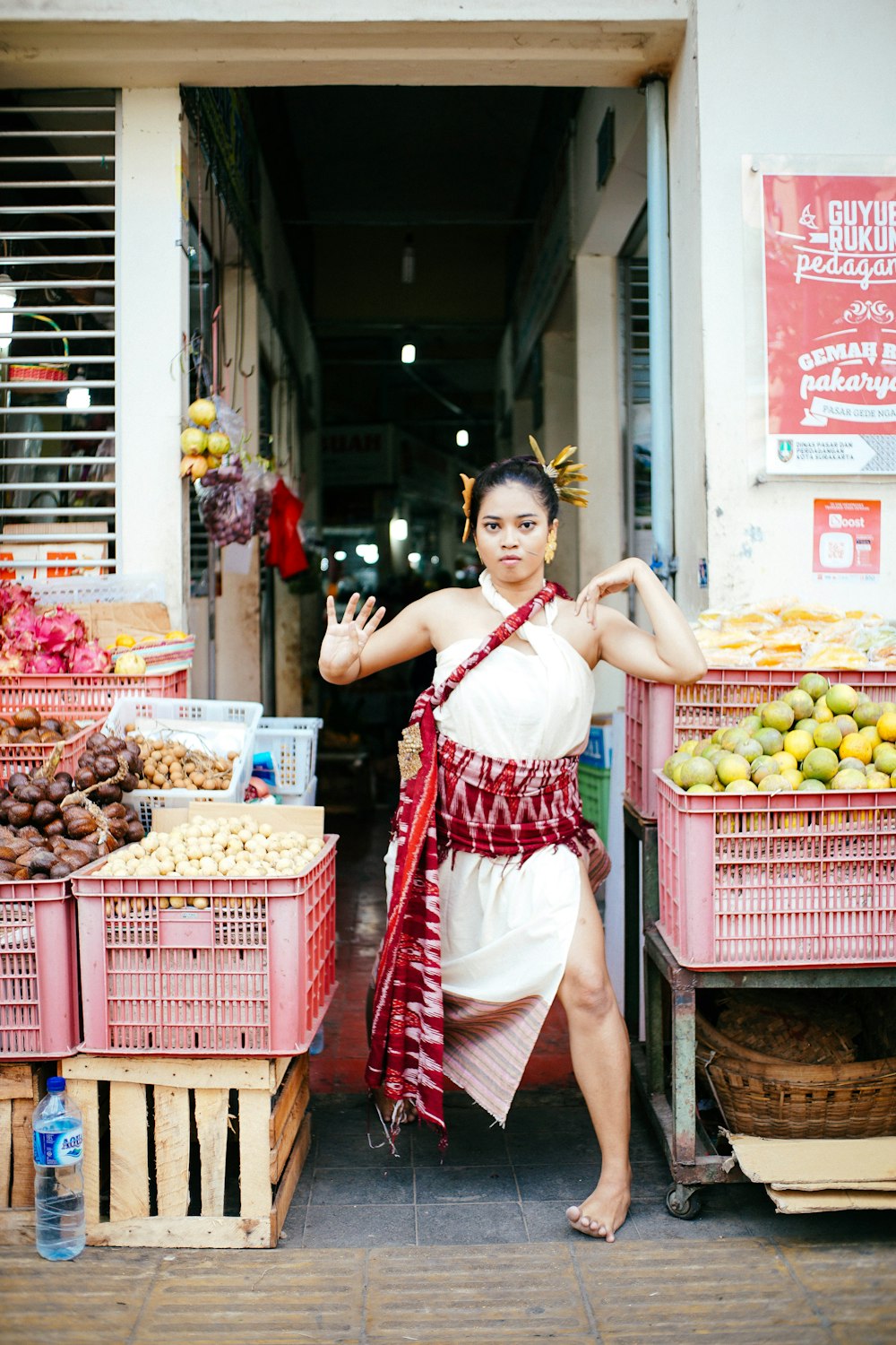 woman standing beside crates of fruits