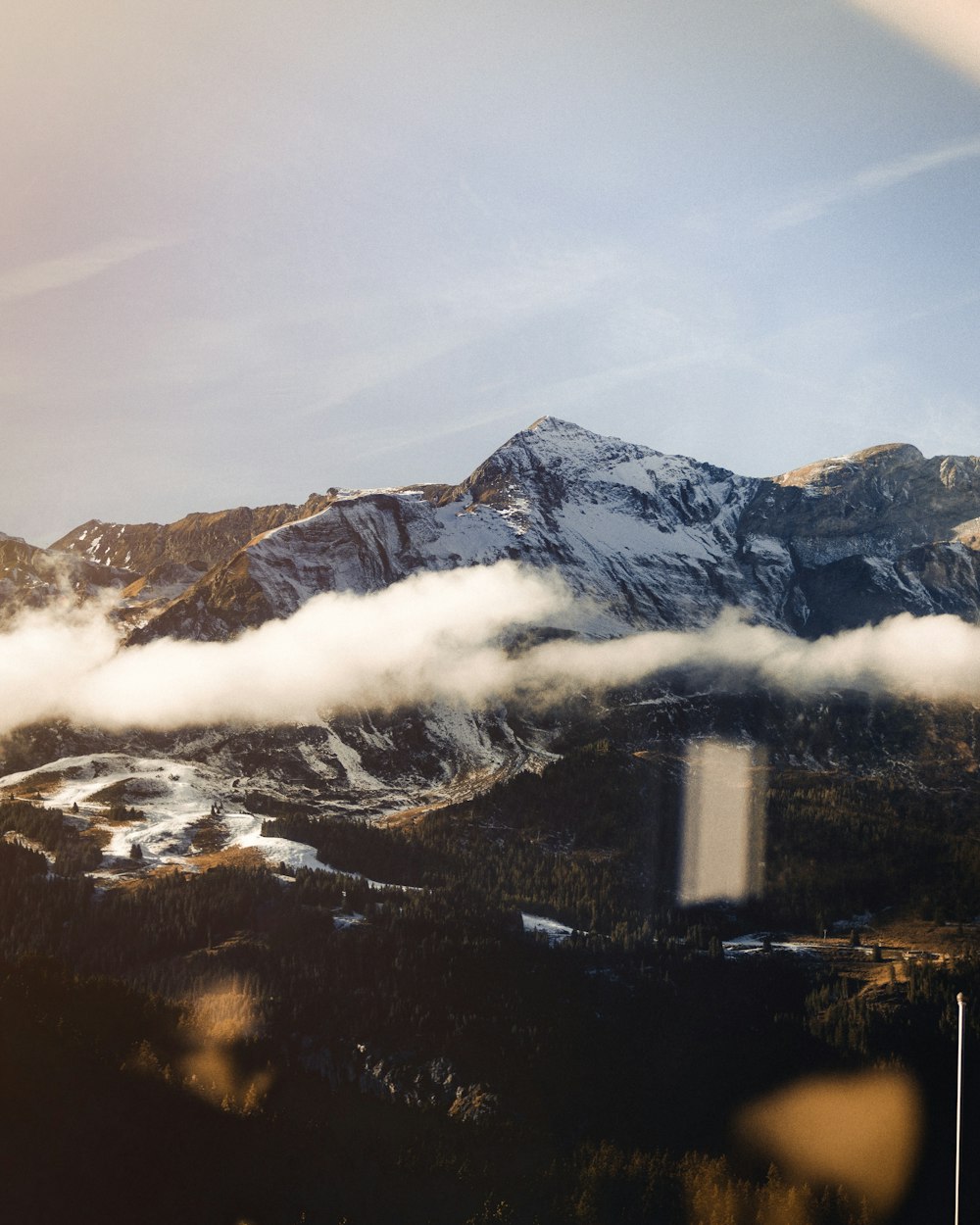 white clouds hovering above the valley near snow covered mountain