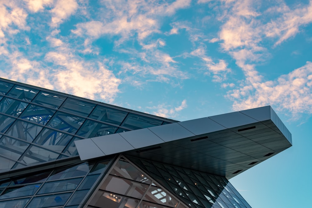 white and gray glass building under blue and white cloudy sky